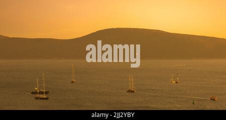 Boote und Sonnenuntergang am Ufer von Bodrum. Ägäis Küste im Sommer. Das berühmte Touristenziel der Türkei Stockfoto