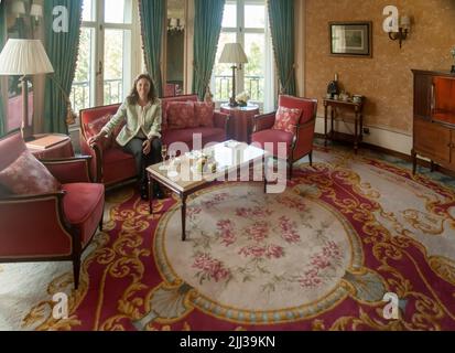 Frau, die in der Suite im Hotel sitzt Stockfoto