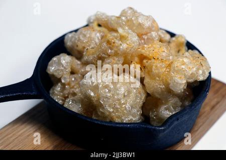 Sonnengetrocknete Fritteuse knusprige Schweinehaut, bekannt als Chicharon in einem Serviergericht, asiatische Delikatessen Stockfoto