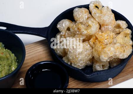 Sonnengetrocknete Fritteuse knusprige Schweinehaut, bekannt als Chicharon in einem Serviergericht, philippinische Delikatessen Stockfoto