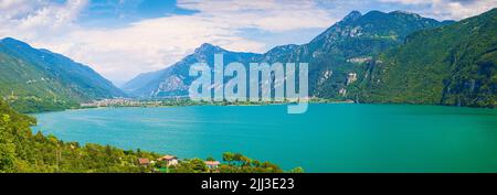 Schöner Blick über den Idrosee Italien. Häuser, ein kleines Dorf auf der Vorder- und blaues Wasser und Berge im Hintergrund. Stockfoto