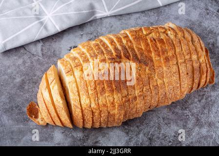 Frischer weißer Laib Brot auf grauem Zementhintergrund. Draufsicht Stockfoto