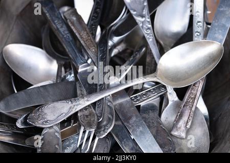 Stapel alter Silbergabeln, Löffel und Messer in einer silbernen Schale Stockfoto