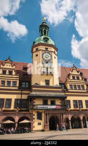 Leipzig, Deutschland - 25. Juni 2022: Das alte Rathaus am Marktplatz mit vielen Touristen auf der Straße. Blauer Himmel über der sächsischen Stadt. Das historische Stockfoto
