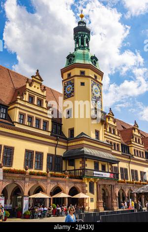 Leipzig, Deutschland - 25. Juni 2022: Das alte Rathaus am Marktplatz mit vielen Touristen auf der Straße. Blauer Himmel über der sächsischen Stadt. Das historische Stockfoto