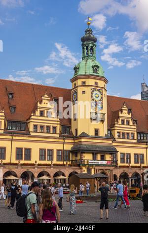 Leipzig, Deutschland - 25. Juni 2022: Das alte Rathaus am Marktplatz mit vielen Touristen auf der Straße. Blauer Himmel über der sächsischen Stadt. Das historische Stockfoto