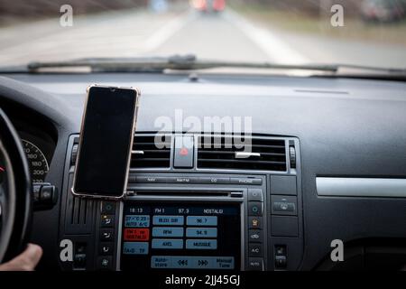 Bild einer Fahrzeugsteuerung mit einem Smartphone, das für die GPS-Navigation verwendet wird. Stockfoto