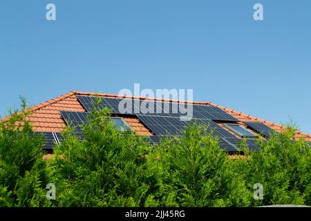 Hausdach mit Photovoltaikmodulen. Historisches Bauernhaus mit modernen Sonnenkollektoren auf Dach und Wand Hochwertiges Foto Stockfoto