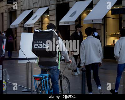 Bild eines Mannes auf einem Fahrrad, der eine Tasche mit dem Logo von Uber trägt, isst für eine lieferung in Bordeaux, Frankreich. Uber Eats ist eine amerikanische Online-Lebensmittelbestellerin Stockfoto