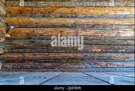 Niedriger Winkel auf den Boden und die Innenwand eines verlassenen Blockhauses Stockfoto