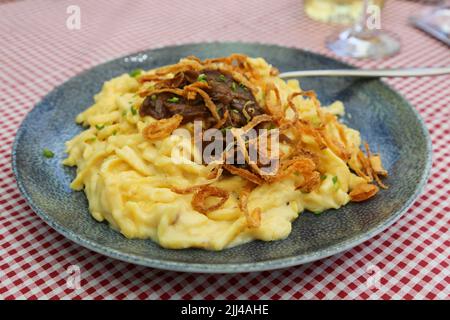 Schwäbische Küche, Käsespätzle mit geschmorten Zwiebeln, traditionelles Restaurant zur Forelle, verschiedene edle Fisch gebraten, Restaurant, Essen, Teller, Essen Stockfoto