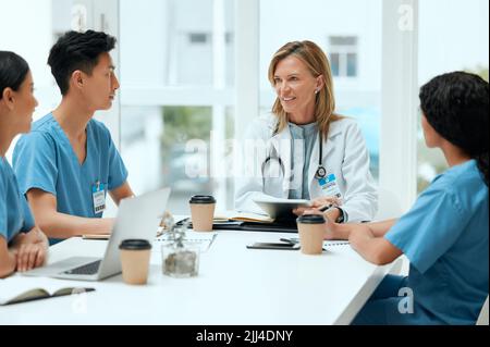 Sie lernen von den Besten im medizinischen Bereich. Eine Gruppe von Ärzten bei einem Treffen in einem Krankenhaus. Stockfoto