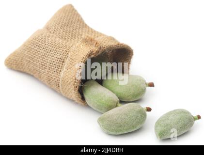 Grüne Mandel in Jutesack auf weißem Hintergrund Stockfoto