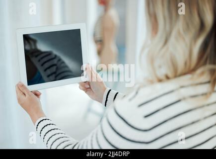 Die besten Ärzte der Welt sind Doctor Diet. Eine unkenntliche Frau, die zu Hause ein digitales Tablet verwendet. Stockfoto