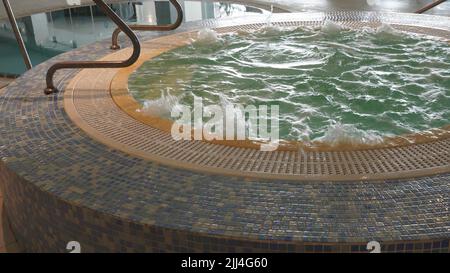 Leerer Whirlpool in Aktion. Whirlpool mit sprudelndem Wasser im Hotel Stockfoto