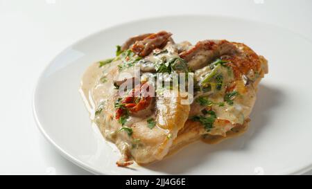 Cremiges italienisches toskanisches Huhn mit Spinat und Pilzen und getrockneten Tomaten Stockfoto