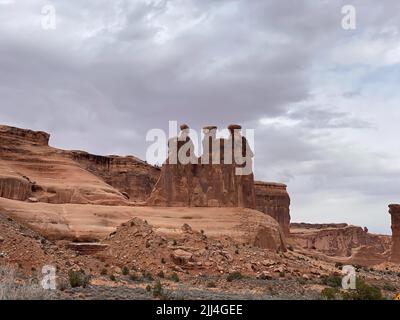 Foto von drei Klatsch Sandstein Turm auf einem Sockel im Courthouse Towers Cluster im Arches National Park in Moab, Utah, USA Fertig Stockfoto