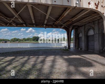 Wohngebäude am linken Ufer und der Schelde von unter einer Brücke am Kai des rechten Antwerpener Ufers in Belgien aus gesehen Stockfoto