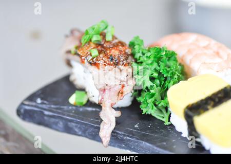 Sushi oder Gyuuniku Sushi, Reis mit rohem Rindfleisch oder Rindfleisch Sushi und Ei Sushi gekrönt Stockfoto
