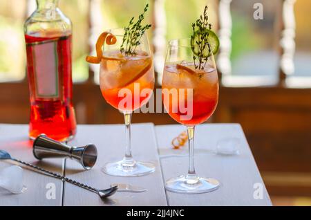 Aperol Stpritz Cocktail mit Eiswürfel und Orangenscheiben auf schwarzen Hintergrund. Klassische italienische Aperitif trinken mit Cocktail Zubehör auf der te Stockfoto