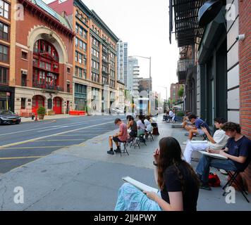 Kunststudenten mit Skizzenpads zeichnen das Feuerhaus auf der Great Jones St in Manhattan, New York, 20. Juli 2022. Stockfoto