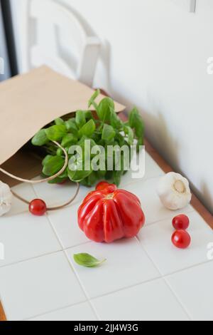 Einkaufen von Lebensmitteln im Supermarkt. Tomaten, Knoblauch und Gemüse auf weißem Tisch Stockfoto