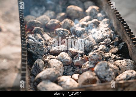 Grill wird bei einem Picknick verwendet, um Fleisch darauf zuzubereiten Stockfoto