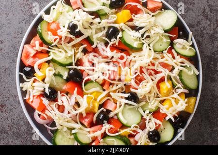 Shopska Salata Gemüse gehackt Salat mit Käse in der Nähe auf dem Teller auf dem Tisch. Horizontale Draufsicht von oben Stockfoto