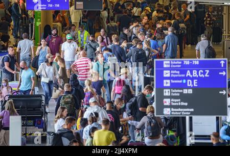 Frankfurt, Deutschland. 23.. Juli 2022. 23. Juli 2022, Hessen, Frankfurt/Main: Reisende warten in langen Warteschlangen und packen sich beim Check-in im Terminal 1 des Frankfurter Flughafens zusammen. Nach dem Start der Sommerferien in Hessen, Rheinland-Pfalz und dem Saarland kam es zu einem starken Ansturm von Passagieren. Am Wochenende werden bis zu 200.000 Passagiere pro Tag am größten deutschen Flughafen erwartet. Foto: Frank Rumpenhorst/dpa Quelle: dpa picture Alliance/Alamy Live News Stockfoto