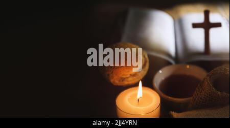 Heilige Kommunion symbolisiert das heilige Blut und Fleisch Jesu Christi Letztes Abendmahl Wein und Brot, das Kreuz des Leidens, Kerzen und die Bibel Stockfoto