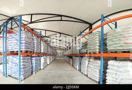 Große Lagerhäuser mit Säcken von Tierfutter. Tierarztproduktion. Tierfutter auf Lager. Paletten mit Ladung Stockfoto