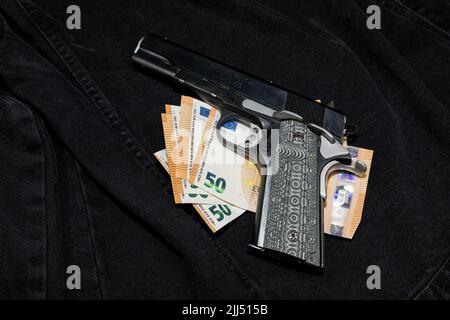 Ein Stapel Banknoten und eine Handfeuerwaffe mit dekorativem Griff Stockfoto