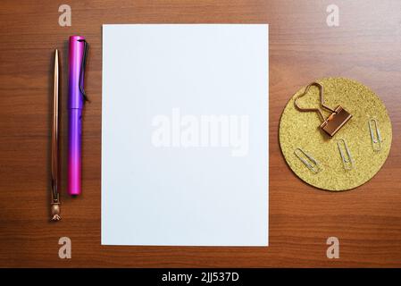 Stück Papier Mit Wichtigen Informationen Auf Dem Schreibtisch Mit Bleistiften Und Büroklammern. Crutial Ankündigungen Präsentiert Auf Dem Notizblatt Auf Dem Tisch Mit Office Stockfoto