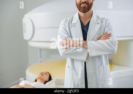 Nahaufnahme der Radiologen kontrolliert MRT oder CT oder PET Scan mit weiblicher Patientin, die sich einem Eingriff unterziehen muss Stockfoto