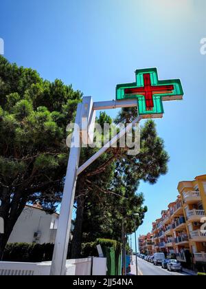 Spanisches Farmacia grün rotes Kreuz Schild vor Apotheke Apotheke Apotheke in Empuriabrava Spanien Stockfoto