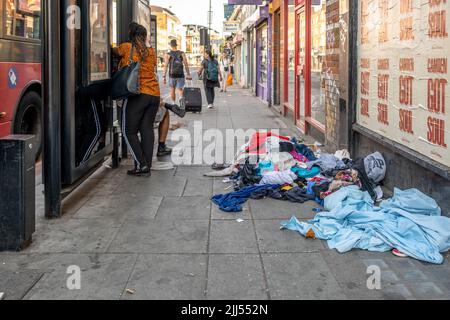 Alte schmutzige Kleider, die in einer Hauptstraße in Camden, North London, England, Großbritannien, abgelegt wurden. Stockfoto