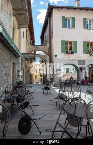 Ein Restaurant und eine Bar in Bormio, mit Stühlen und Tischen draußen, SO, Valtellina, Italien Stockfoto