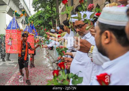 Neu-Delhi, Indien. 22.. Juli 2022. Menschen, die der muslimischen Gemeinschaft angehören, duschen Blütenblätter auf Kanwariyas, Anhänger der Hindu-Gottheit Shiva, während sie während der Kanwar Yatra im Monat Shravan in Neu-Delhi heiliges Wasser aus dem Ganga-Fluss transportieren. Die Kanwar Yatra ist eine jährliche Pilgerfahrt, bei der die Anhänger safranfarbene Kleidung tragen und barfuß laufen, um das heilige Wasser von den ausgewählten Pilgerzielen zu sammeln. Kredit: SOPA Images Limited/Alamy Live Nachrichten Stockfoto