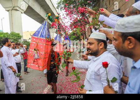 Neu-Delhi, Indien. 22.. Juli 2022. Menschen, die der muslimischen Gemeinschaft angehören, duschen Blütenblätter auf Kanwariyas, Anhänger der Hindu-Gottheit Shiva, während sie während der Kanwar Yatra im Monat Shravan in Neu-Delhi heiliges Wasser aus dem Ganga-Fluss transportieren. Die Kanwar Yatra ist eine jährliche Pilgerfahrt, bei der die Anhänger safranfarbene Kleidung tragen und barfuß laufen, um das heilige Wasser von den ausgewählten Pilgerzielen zu sammeln. (Foto: Amarjeet Kumar Singh/SOPA Images/Sipa USA) Quelle: SIPA USA/Alamy Live News Stockfoto