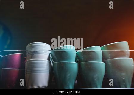 Set aus Keramikbechern oder Tassen, die auf einer professionellen Kaffeemaschine erhitzt werden Stockfoto
