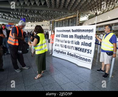 Frankfurt, Deutschland. 23.. Juli 2022. 23. Juli 2022, Hessen, Frankfurt/Main: Mitarbeiter verschiedener Unternehmen und Dienstleister am Frankfurter Flughafen demonstrieren am Nachmittag in der Abflughalle für bessere Arbeitsbedingungen, mehr Geld und Kündigungsschutz. Nach dem Start der Sommerferien in Hessen, Rheinland-Pfalz und dem Saarland gab es einen starken Ansturm von Passagieren. Am Wochenende werden bis zu 200.000 Passagiere pro Tag am größten deutschen Flughafen erwartet. Foto: Frank Rumpenhorst/dpa Quelle: dpa picture Alliance/Alamy Live News Stockfoto