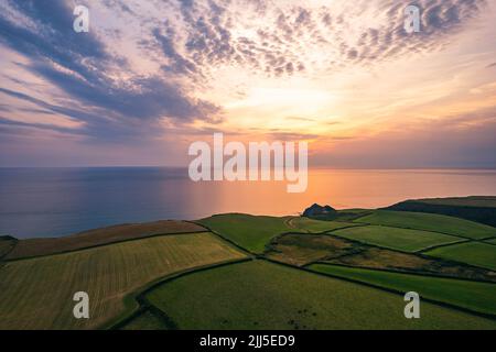 Sonnenuntergang über Feldern und Farmen von Caunter Beach and Cliffs, Hartland Cornwall Heritage Coast, South West Coast Path, Bude, North Cornwall, England Stockfoto