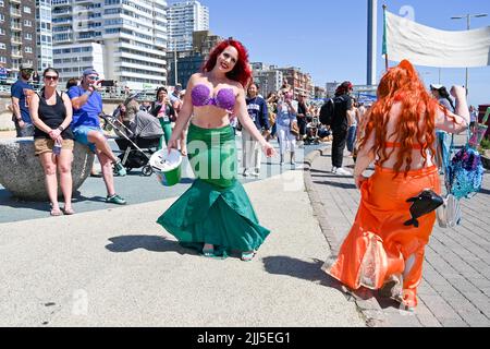 Brighton UK 23. July 2022 - die Parade der Meerjungfrauen geht heute bei heißer Sonne an der Strandpromenade von Brighton entlang. Die jährliche Parade ist eine Feier des Meeres und Geld für die Marine Conservation Society zu sammeln. : Credit Simon Dack / Alamy Live News Stockfoto