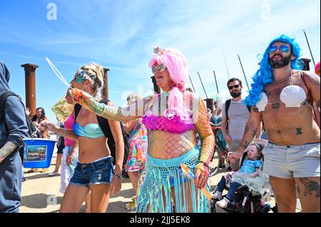 Brighton UK 23. July 2022 - die Parade der Meerjungfrauen geht heute bei heißer Sonne an der Strandpromenade von Brighton entlang. Die jährliche Parade ist eine Feier des Meeres und Geld für die Marine Conservation Society zu sammeln. : Credit Simon Dack / Alamy Live News Stockfoto