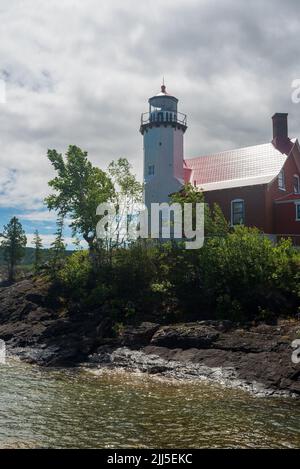 Der Eagle Harbor Lighthouse steht über einem felsigen Eingang zu Eagle Harbor Stockfoto