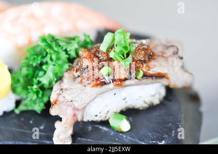 Sushi oder Gyuuniku Sushi, Reis mit rohem Rindfleisch oder Rindfleisch Sushi und Ei Sushi gekrönt Stockfoto