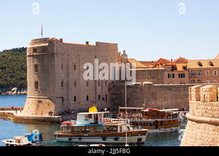 Blick über den Hafen im historischen Stadtzentrum von Dubrovnik, Kroatien mit einem Teil der Festung und der umliegenden Stadtmauer. Stockfoto