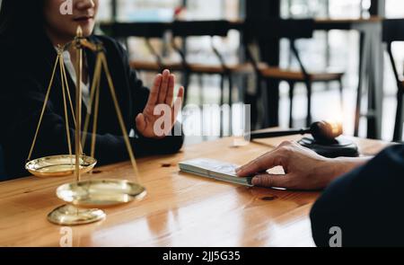 Nahaufnahme eines Anwalts, der sich weigert, von einem Kunden zu stammen, eine Vereinbarung zu treffen Korruption, Richter Gavel, Messingskala, Anwaltskanzlei, unehrlich, Recht Stockfoto