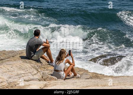 Paar sitzen auf den Felsen auf Beaver Tail in Jamestown, Rhode Islans Stockfoto