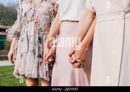 Freunde halten sich an sonnigen Tagen im Park die Hände Stockfoto